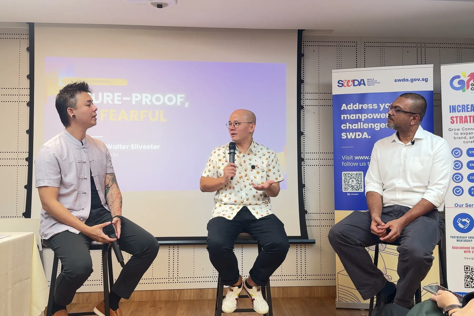 Haojun See speaking on the Towkay Talks Series 5 panel, seated between the moderator and Walter Silvester of Silvester Legal LLC