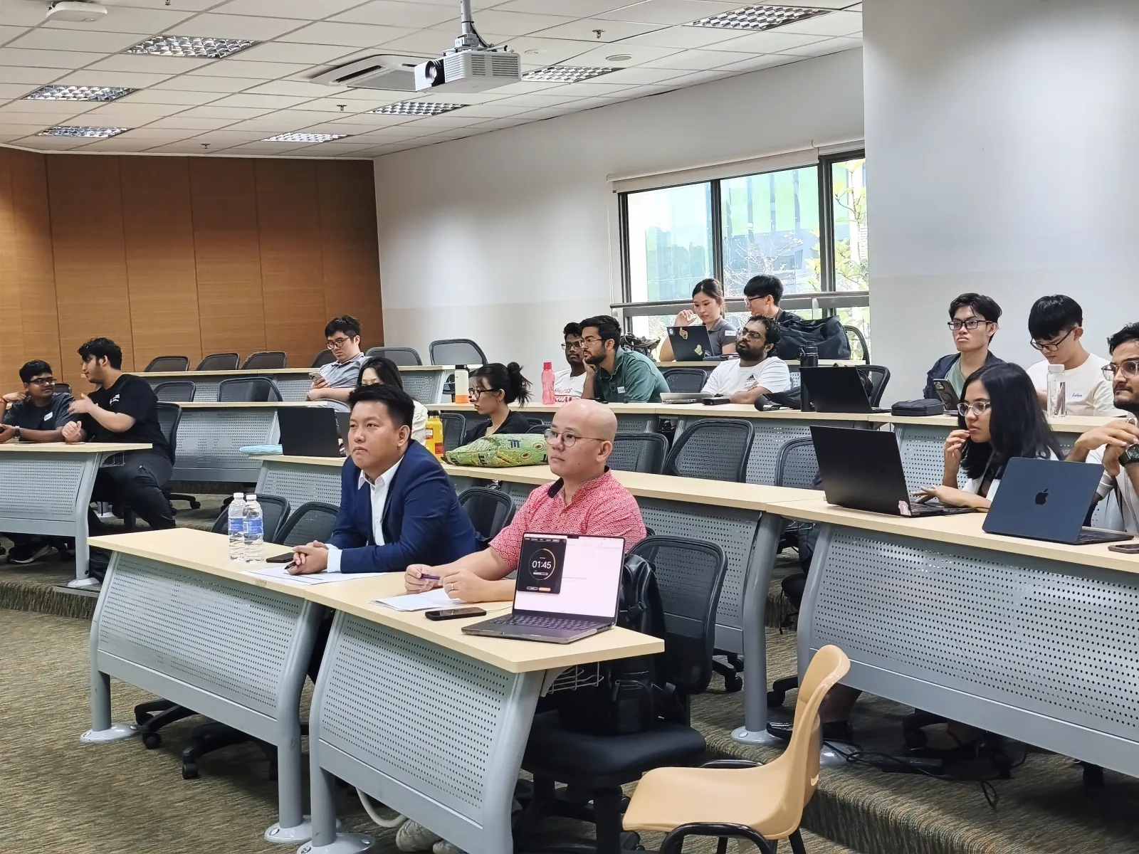 Judging panel listening to a team's pitch at Vibe for Good 2026, Ngee Ann Polytechnic, with participants seated behind